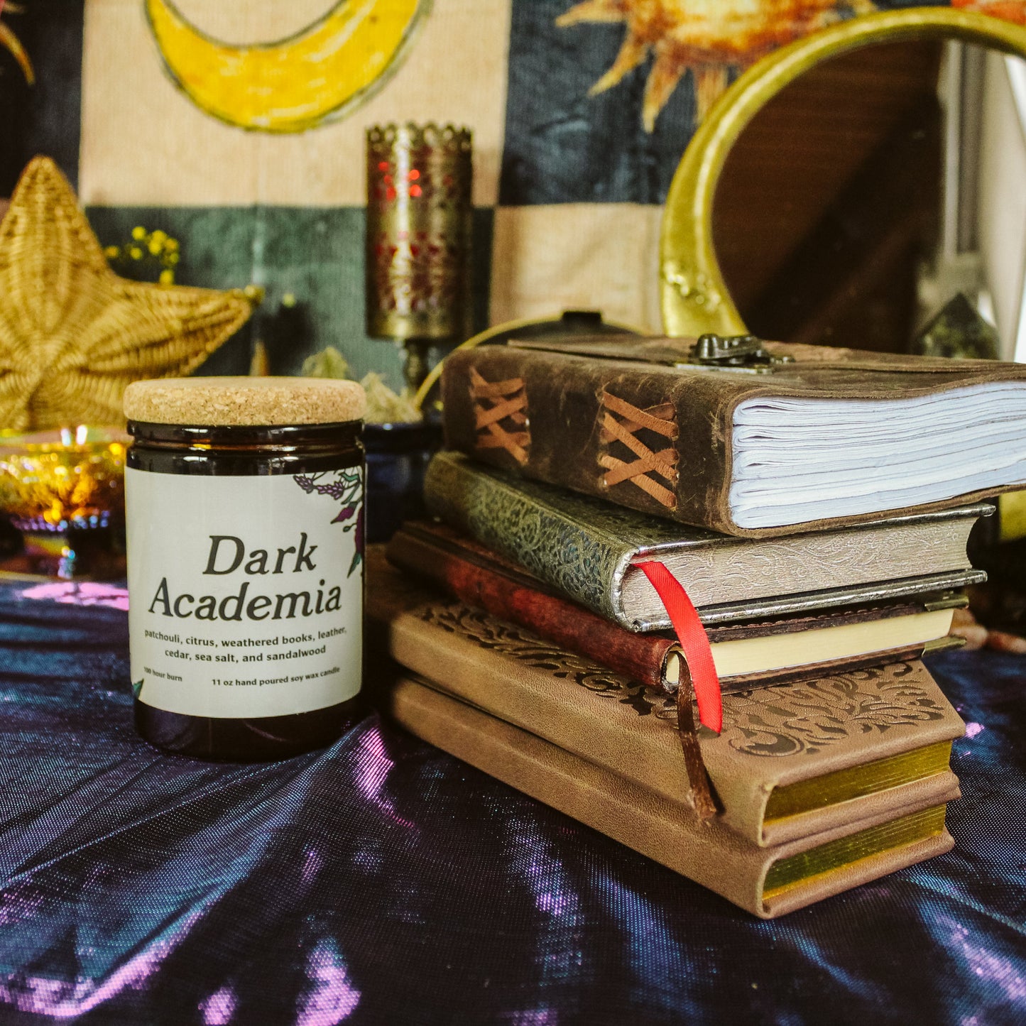 Candle labeled 'Dark Academia' on a table with books and decorative items.