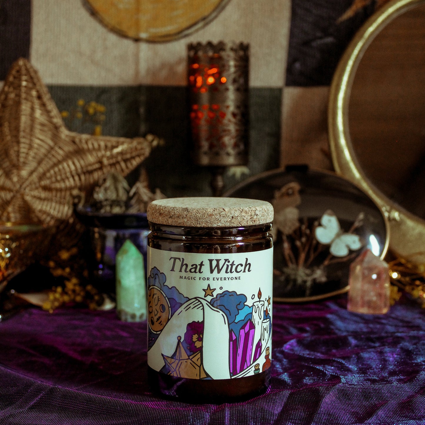 Jar labeled 'That Witch' on a purple cloth with mystical decor in the background