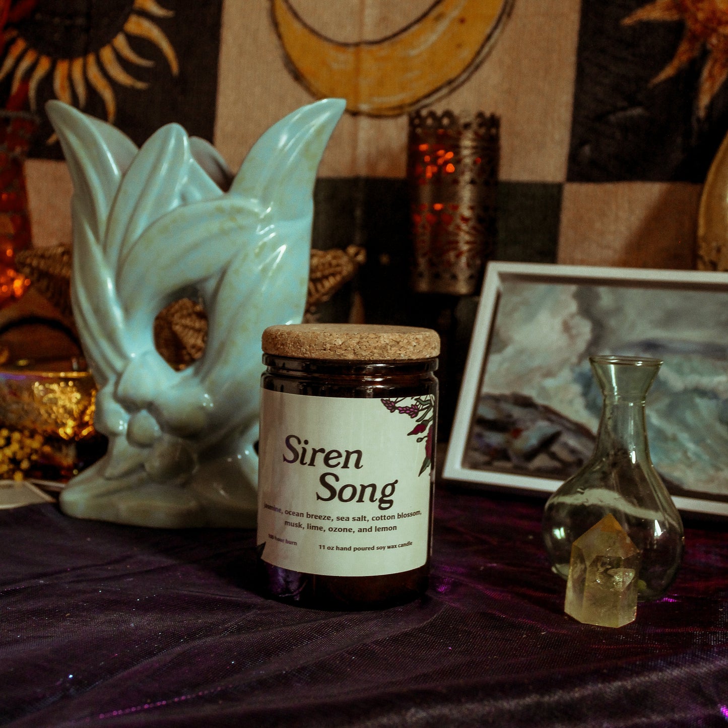 Jar labeled 'Siren Song' on a table with mystical decor including a skull and candles.