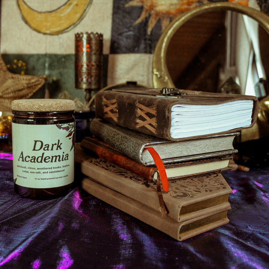 Jar labeled 'Dark Academia' on a table with books and decorative items.