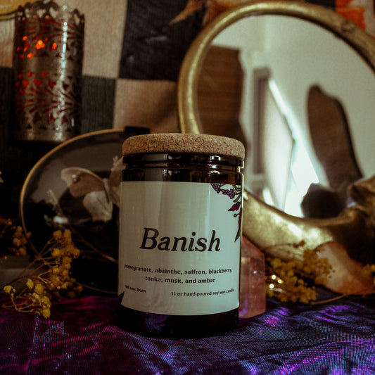 Jar labeled 'Banish' on a mystical background with candles and mirrors.