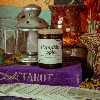 Pumpkin spice jar on a tarot table with candles and cards