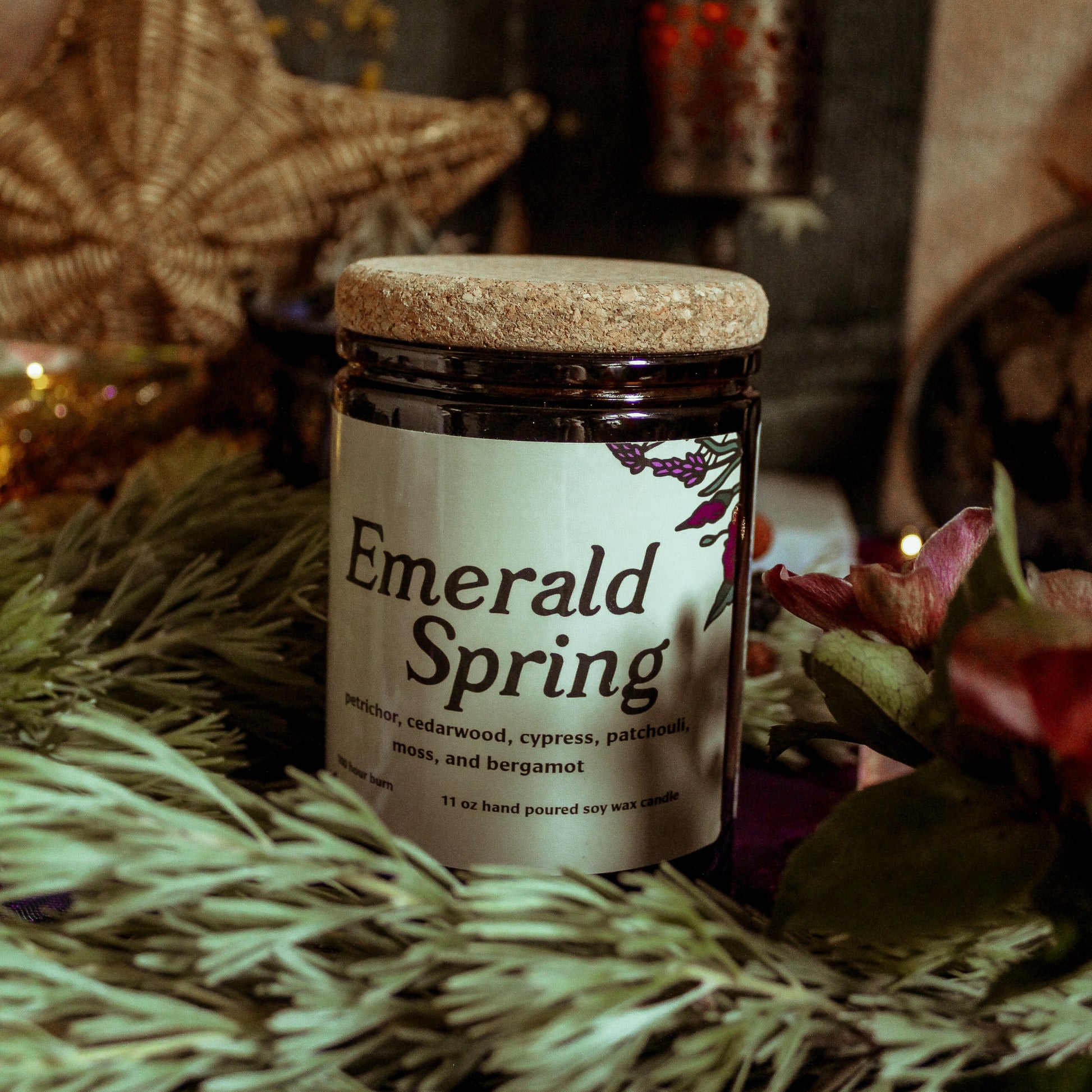 Jar of 'Emerald Spring' candle on a textured surface with decorative background