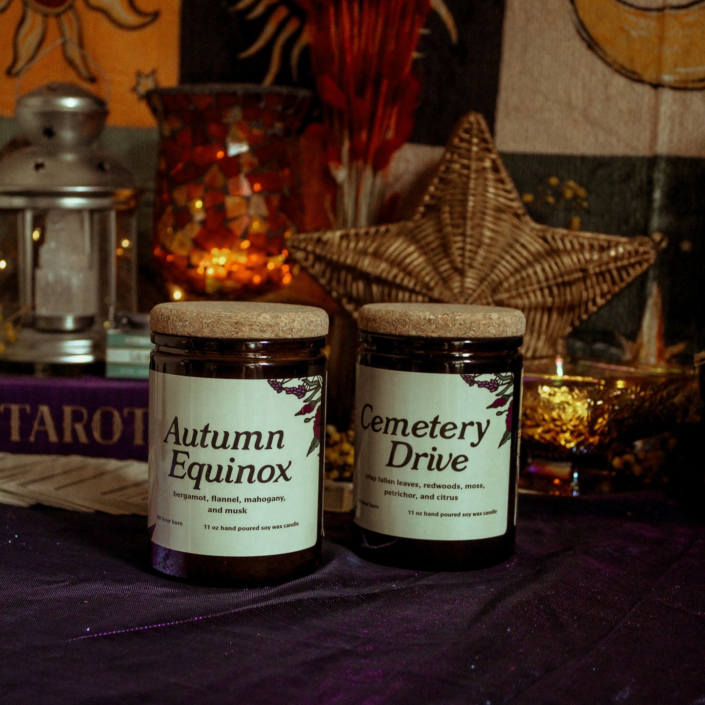 Two jars labeled 'Autumn Equinox' and 'Cemetery Drive' on a table with mystical decor.
