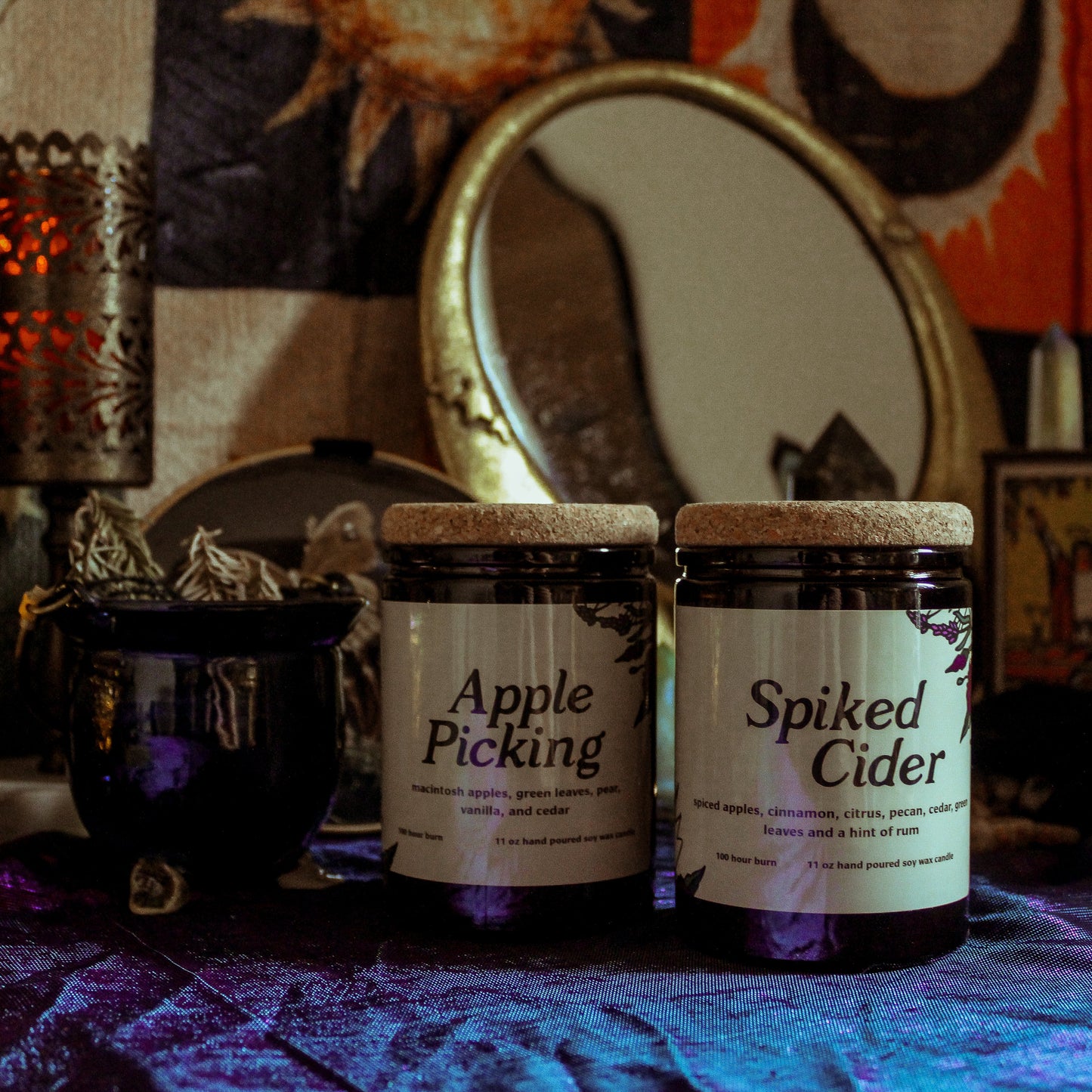 Two jars labeled 'Apple Picking' and 'Spiked Cider' on a table with a mystical background.