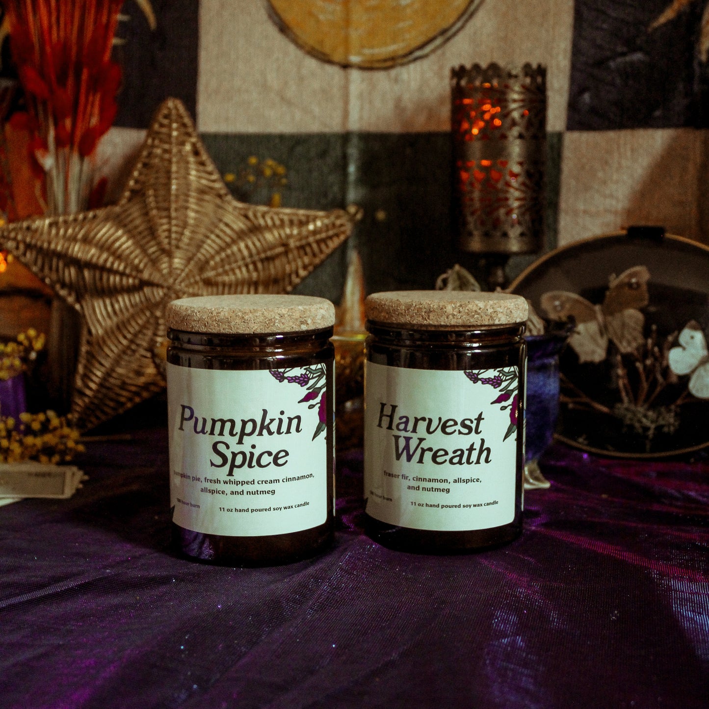 Two jars labeled 'Pumpkin Spice' and 'Harvest Wreath' on a purple surface with a star and moon decoration in the background.
