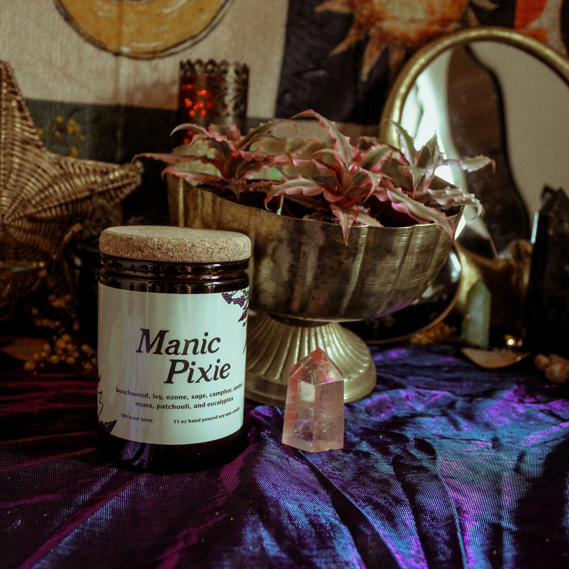 Jar labeled 'Manic Pixie' on a mystical table with candles, crystals, and decorative items.